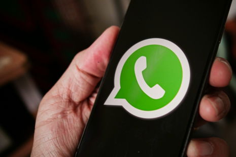 a person holding a cell phone with a whatsapp on it